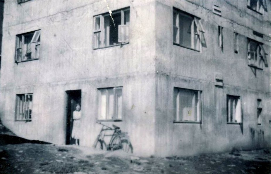 Mamma í dyrumum á nýbyggðum verkamannabústaðnum 